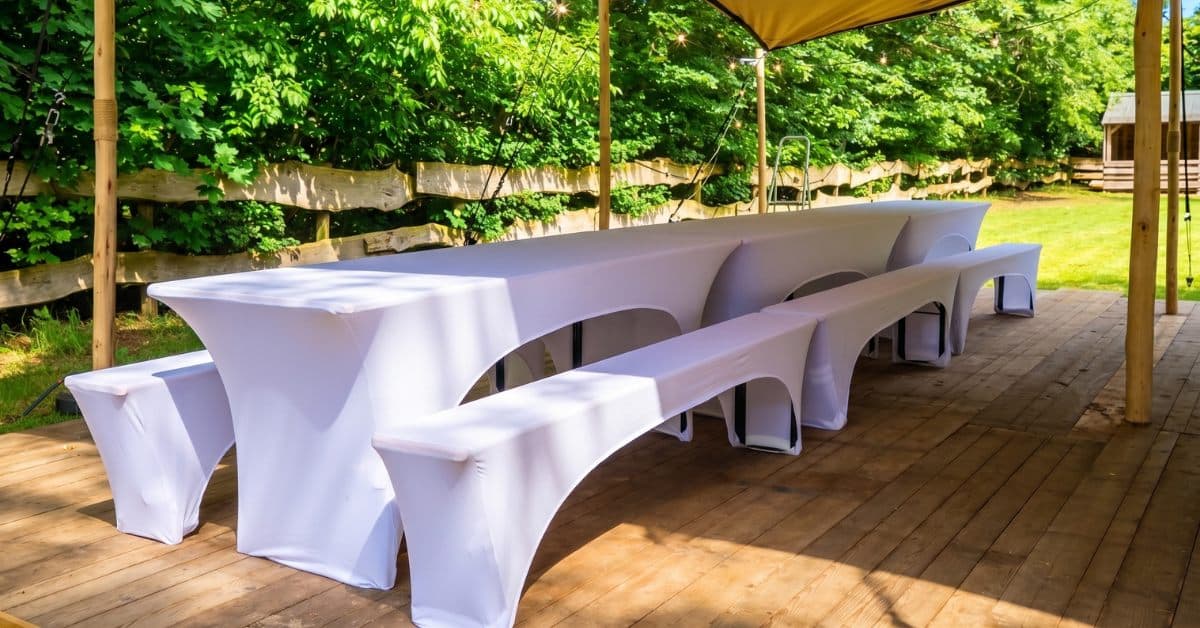 Biertafel en bierbanken met witte hoezen op een houten vlonder