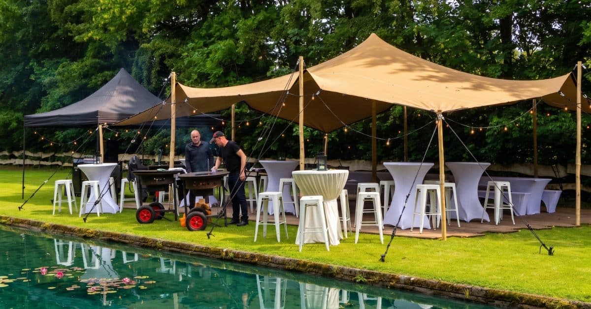 Stretchtent met statafels aan de vijver